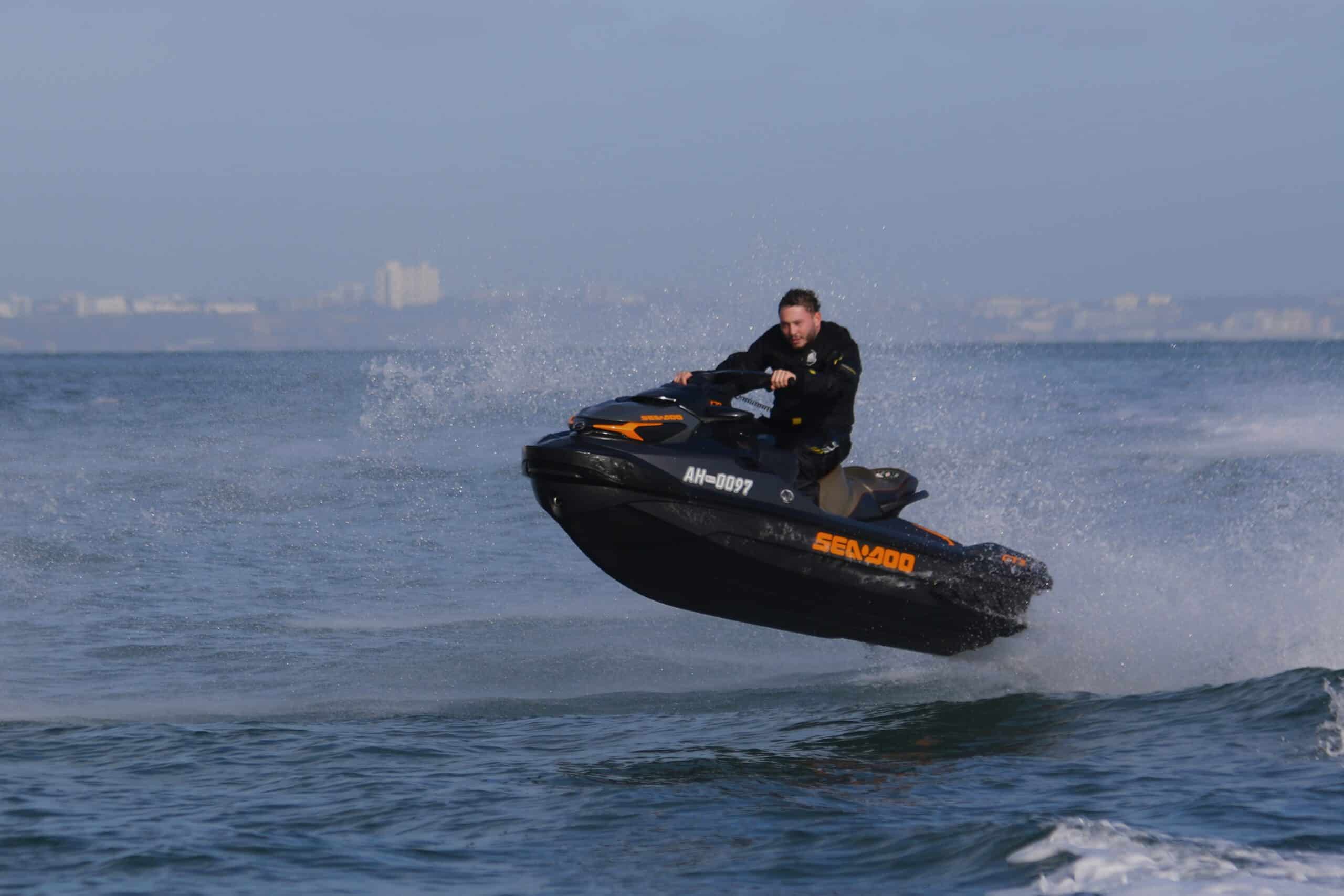 Person riding a jet ski performing a jump on the water.