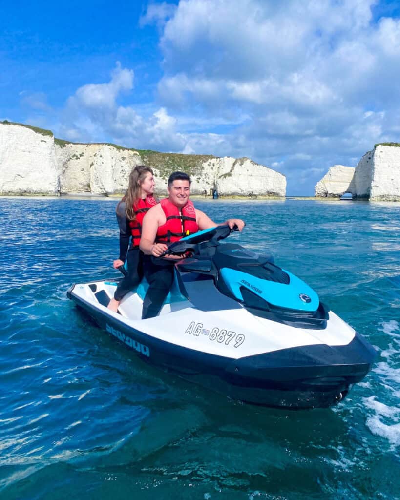 Jet Ski ride with two people on the water near white cliffs.
