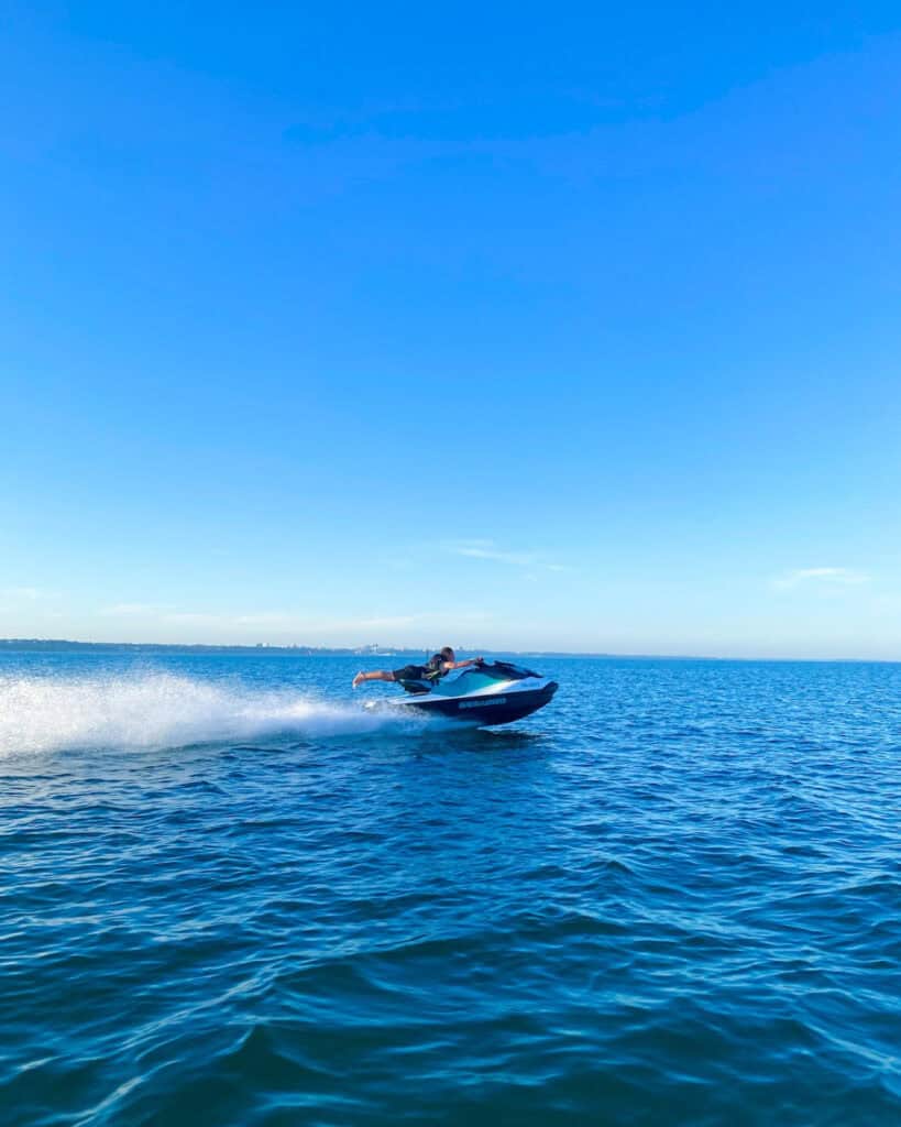 Person riding a jet ski at high speed on the open sea.