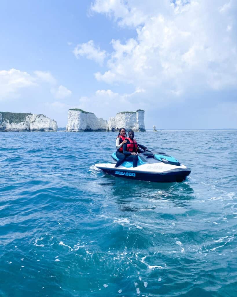 Jet Ski tour with two riders on the water near white cliffs.
