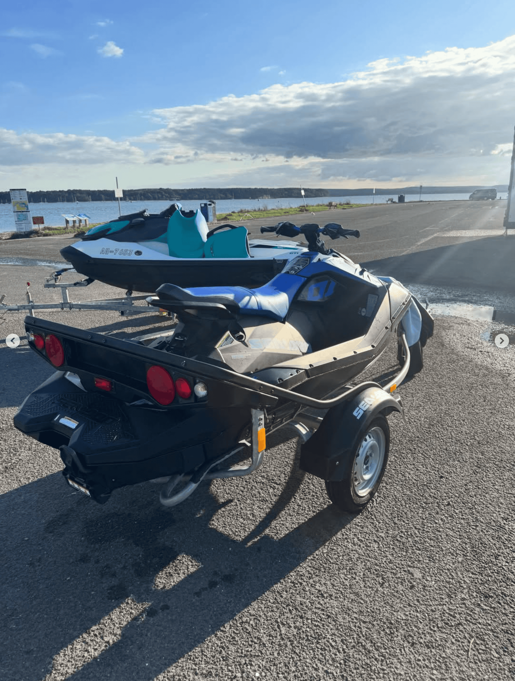 Jet ski on trailer at South Coast Jet Ski Marine with water and sky background.