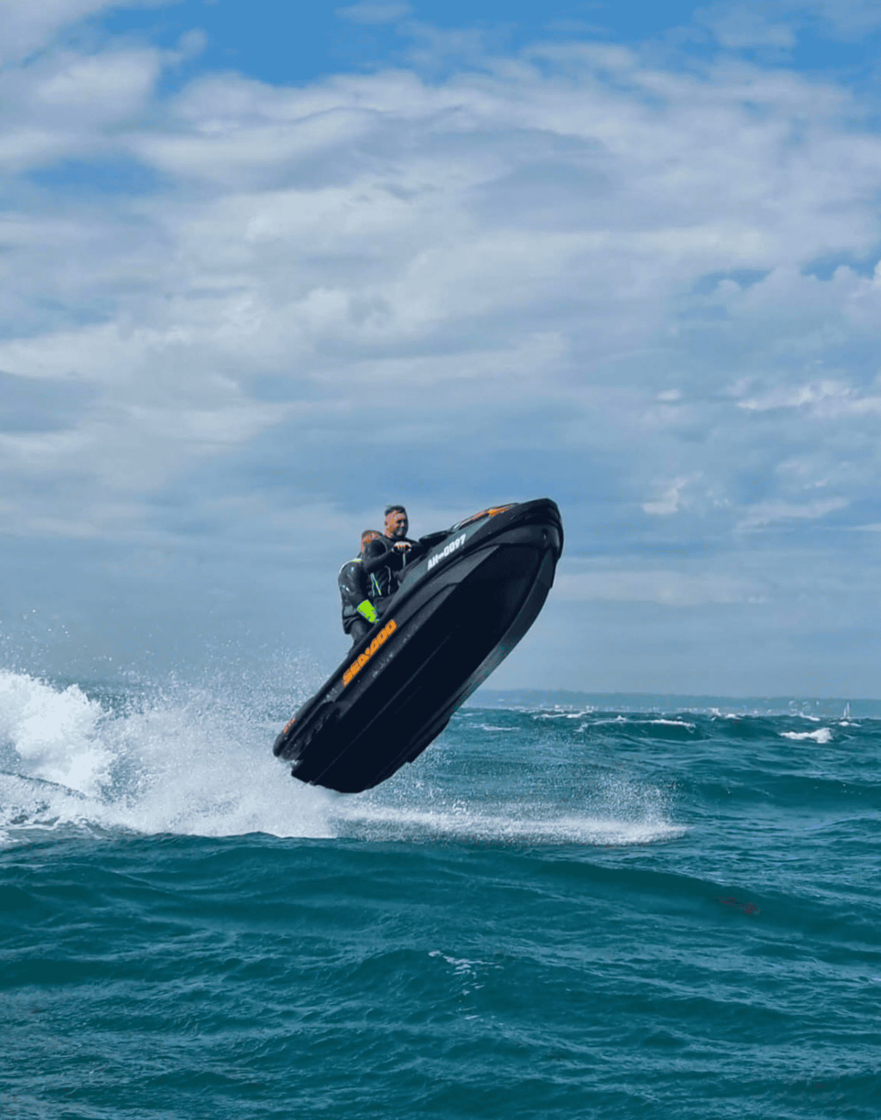 Jet Ski Marine activity with rider jumping over water.